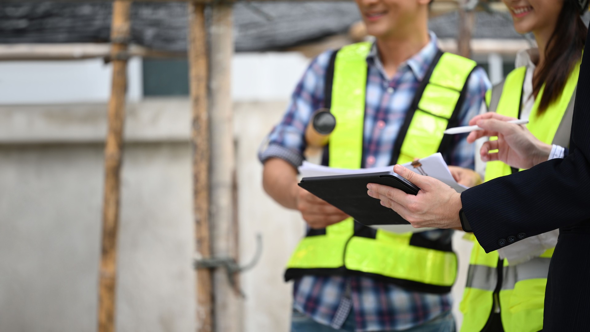 Close-up of a businessman and workers discussing a project on a tablet, copy space for text, Collaborative planning with technology on construction sites